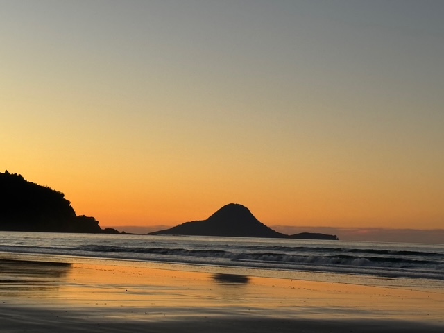 Coastal sunrise with island silhouette in Aotearoa New Zealand